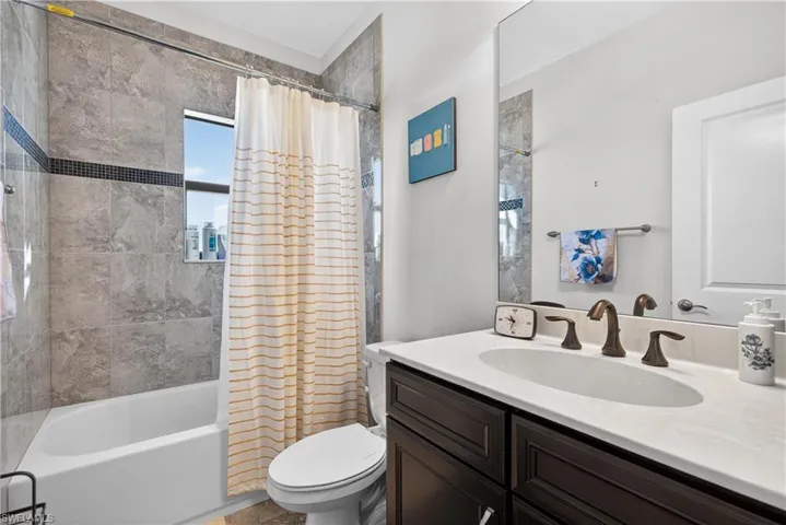 Full bath featuring shower / bath combo with shower curtain and vanity