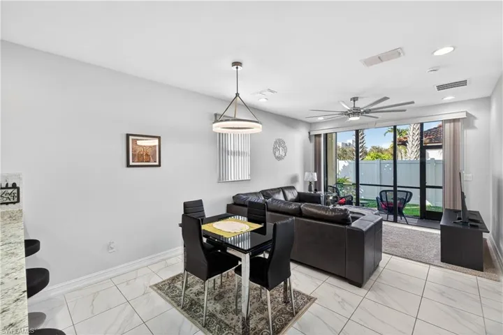 Dining space with a ceiling fan, light marble finish flooring, and recessed lighting