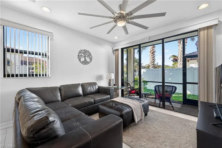 Living room with recessed lighting, light tile patterned floors, ceiling fan, and healthy amount of natural light