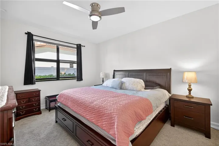 Bedroom with a ceiling fan and light carpet