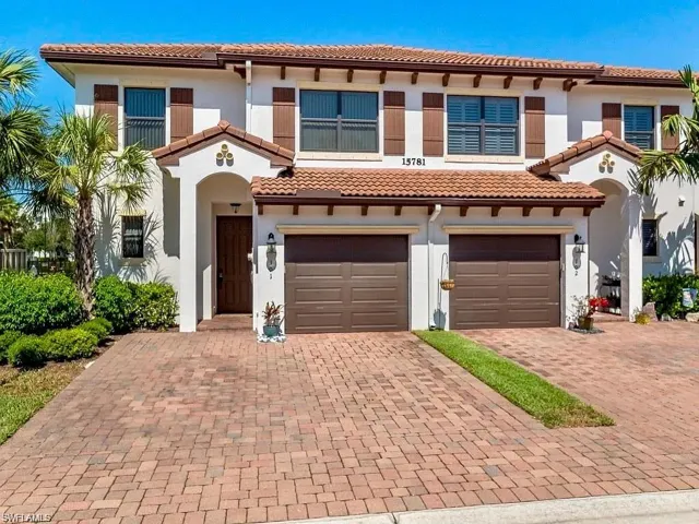 Mediterranean / spanish-style house featuring a tile roof, an attached garage, stucco siding, and decorative driveway