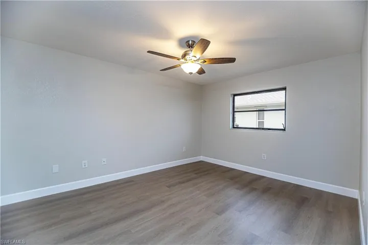 Spare room featuring ceiling fan and dark wood-type flooring
