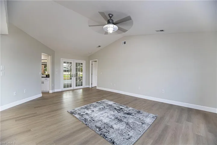 Living room featuring light hardwood / wood-style flooring, vaulted ceiling, and ceiling fan
