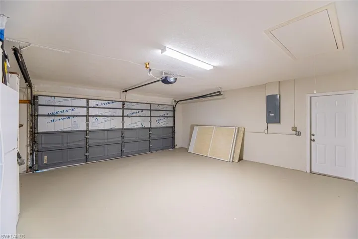 Garage featuring electric panel and a garage door opener