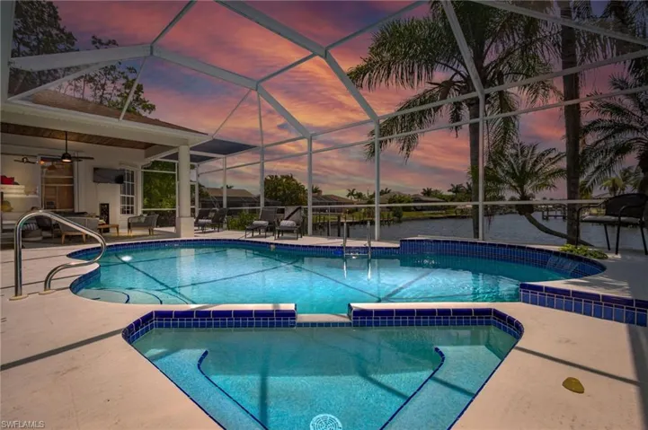 View of pool with ceiling fan, a patio area, glass enclosure, and a pool with connected hot tub