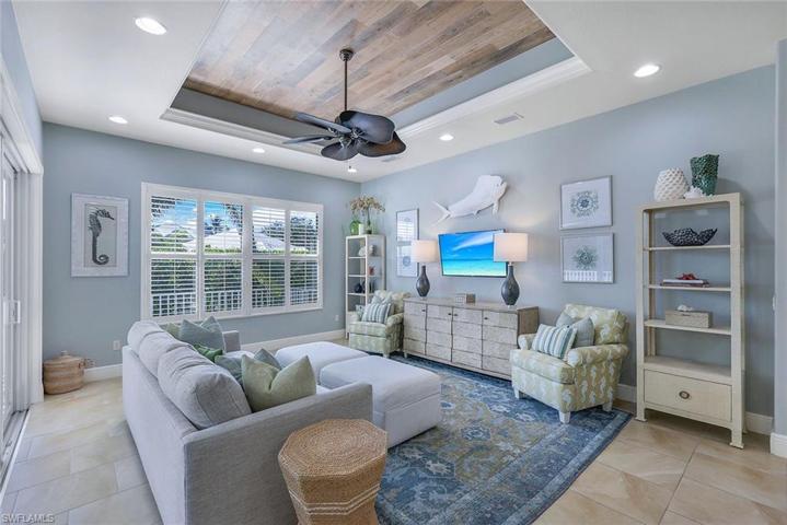 A Great Room that REALLY is Great! Tray Ceiling with Warm Wood Tones, Plantation Blinds, Wall of Sliders, Soft Lighting