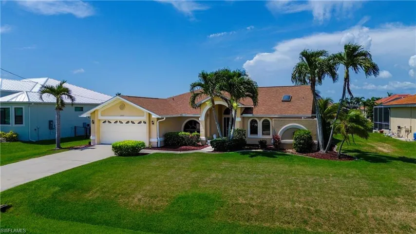 View of front of house featuring a garage and a front lawn