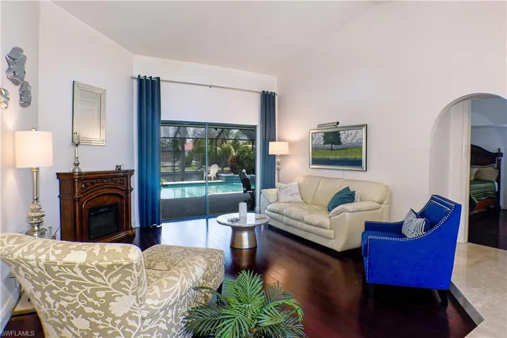 Living room with hardwood / wood-style flooring and vaulted ceiling