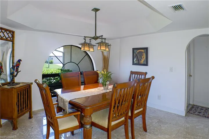 Tiled dining area featuring a raised ceiling