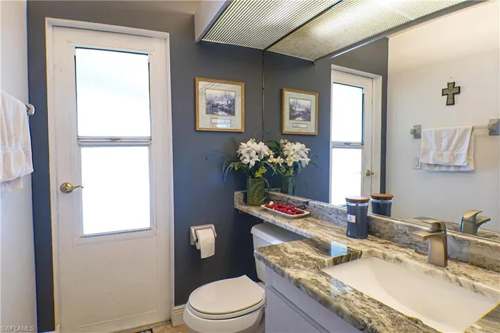 Bathroom featuring a healthy amount of sunlight, toilet, and vanity
