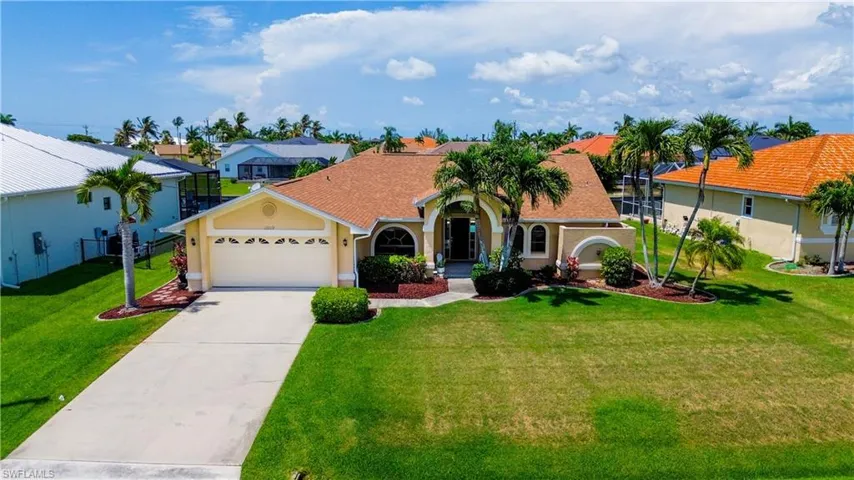 View of front of home with a garage and a front lawn