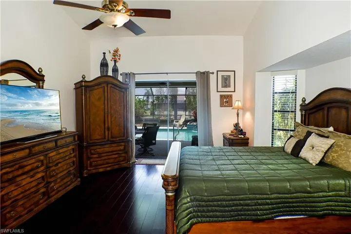 Bedroom with access to outside, lofted ceiling, dark wood-type flooring, and ceiling fan