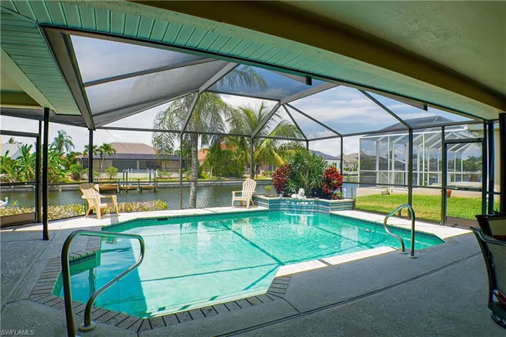 View of swimming pool featuring glass enclosure and a patio