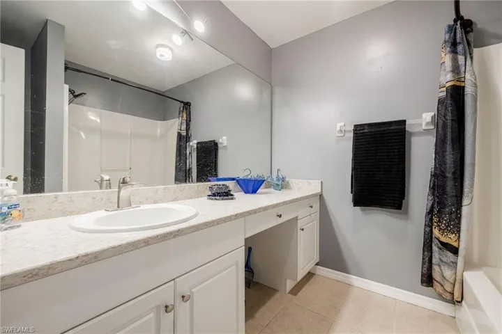 Full bathroom featuring tile patterned flooring, vanity, and baseboards