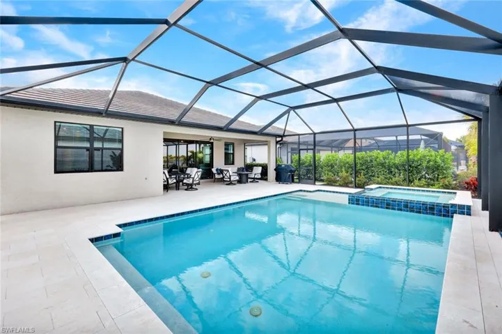 Relaxing pool / spa with a sunroom, glass enclosure, and a patio
