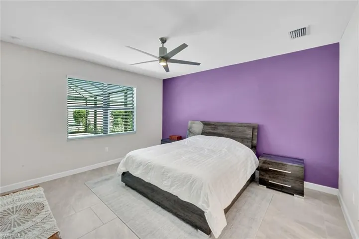 Bedroom with a ceiling fan and an accent wall