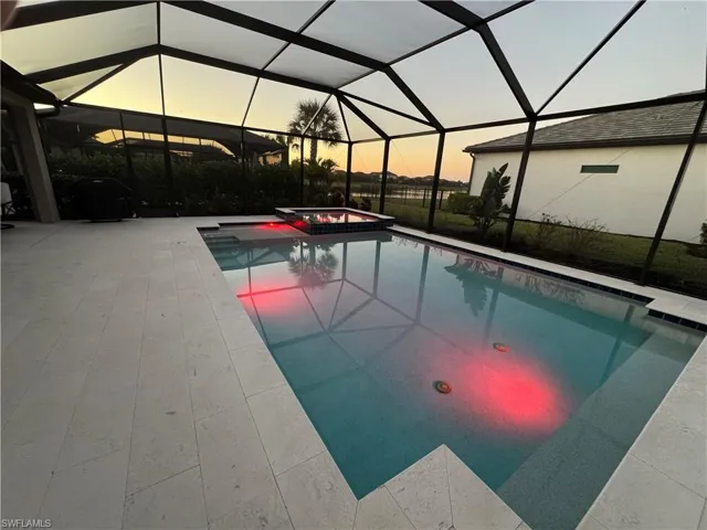 Integrated pool / hot tub with a lanai, a sunroom, and a patio