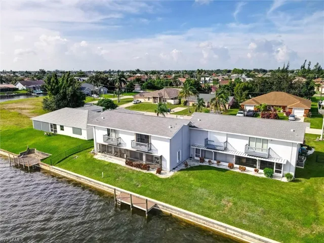 Canal-front property with multiple boat docks, screened lower-level patios, and upper-level balconies
