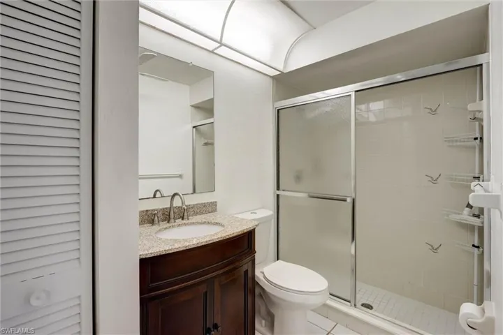 Dark wood-finish vanity with a granite-style countertop and undermount sink