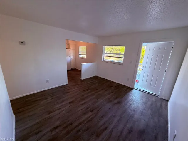 Entryway with dark wood-type flooring and a textured ceiling
