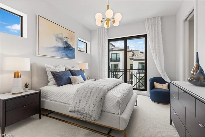 Bedroom featuring light carpet and an inviting chandelier