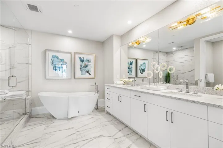 Bathroom featuring vanity and separate shower and tub