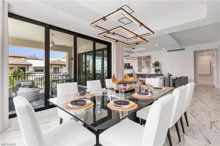 Dining area with ceiling fan with notable chandelier