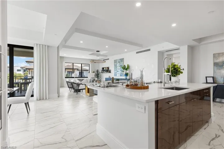 Kitchen featuring an island with sink and sink