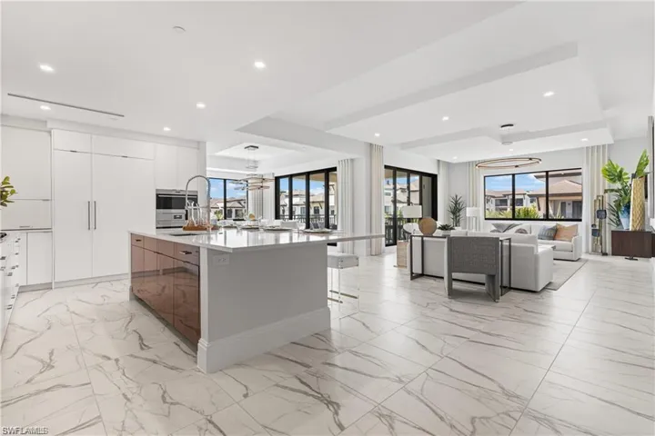Kitchen with a kitchen bar, white cabinetry, and a kitchen island with sink