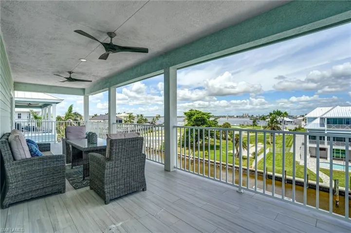 EXPANSIVE Deck featuring a patio, a ceiling fan, outdoor lounge area, and a water view - Virtually Edited Image