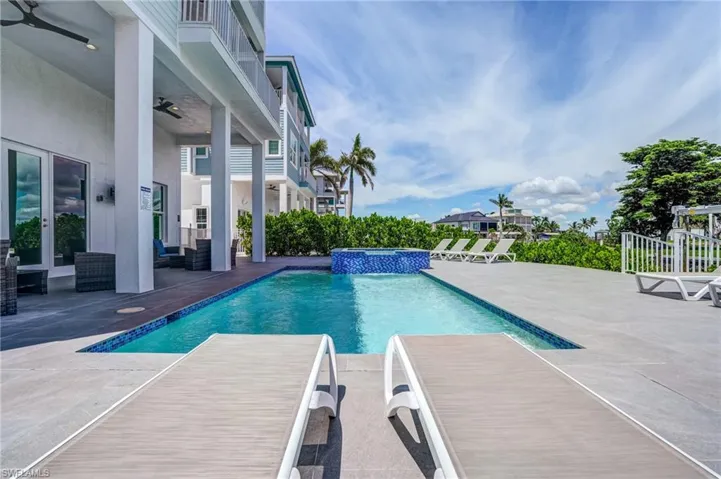 Long View of swimming pool featuring a patio, a ceiling fan, and a pool with connected hot tub - Virtually Edited Image