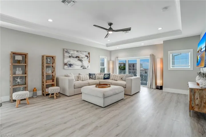 Top Floor Relaxation area with ceiling fan, light wood-type flooring, recessed lighting, and a tray ceiling - Virtually Edited Image