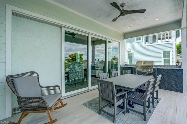 Deck featuring area for grilling, outdoor dining area, and ceiling fan - Virtually Edited Image