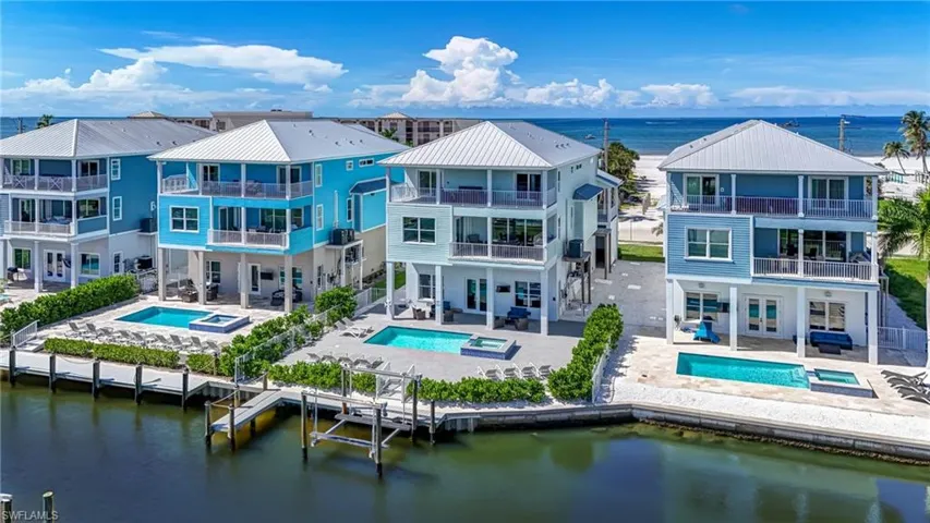 Bring your Bathing Suit? Lets go Swimming - Back of property with an in-ground hot tub, a water view, and a patio - Virtually Edited Image