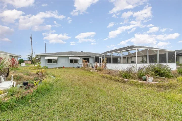 Back of property with a yard and glass enclosure