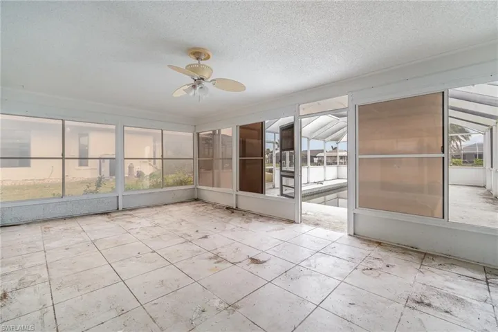 Unfurnished sunroom with ceiling fan and plenty of natural light