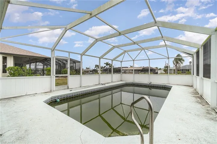 View of swimming pool with a patio area and glass enclosure