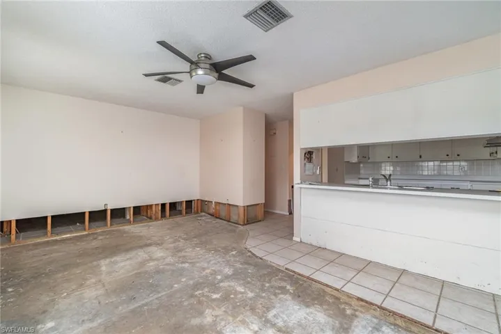 Kitchen with a textured ceiling, ceiling fan, and backsplash
