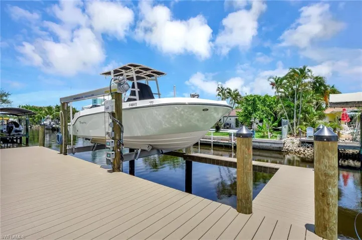 Dock area featuring boat lift and a water view