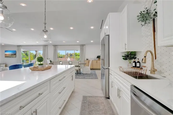 Kitchen featuring white cabinetry, light stone counters, and stainless steel appliances
