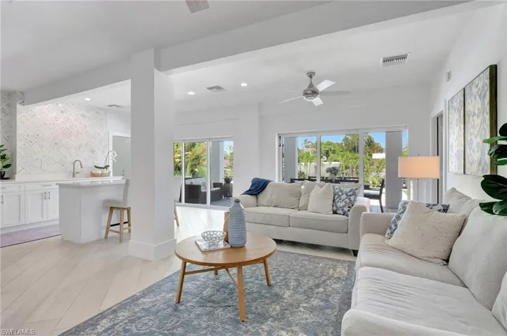 Living area with ceiling fan, recessed lighting, and light wood-style flooring