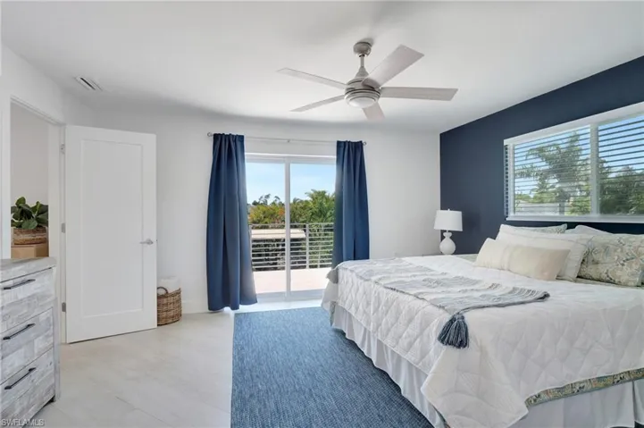 Bedroom featuring access to exterior, a ceiling fan, and light wood finished floors