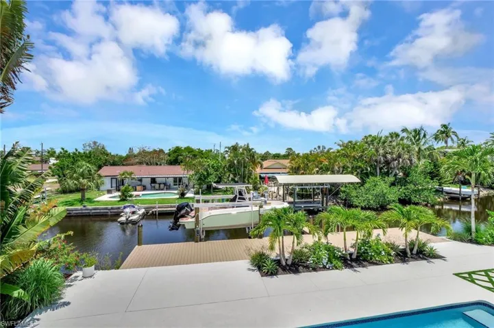 View of swimming pool featuring a boat dock, a water view, and boat lift