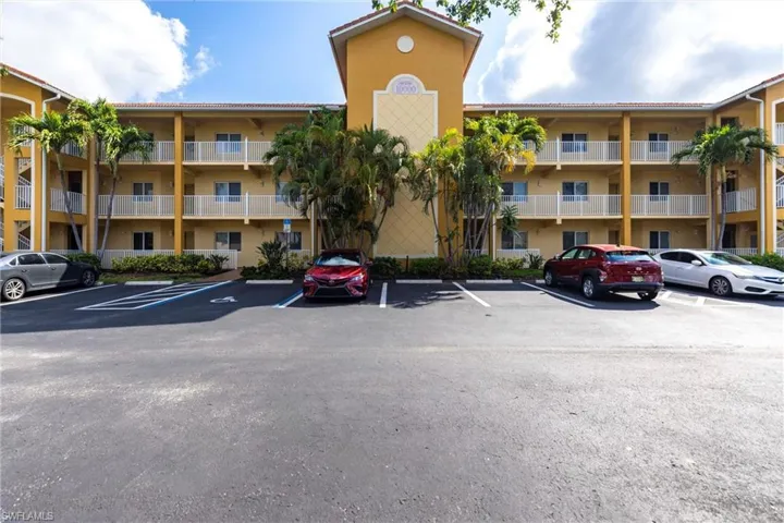 View of apartment building / complex featuring uncovered parking