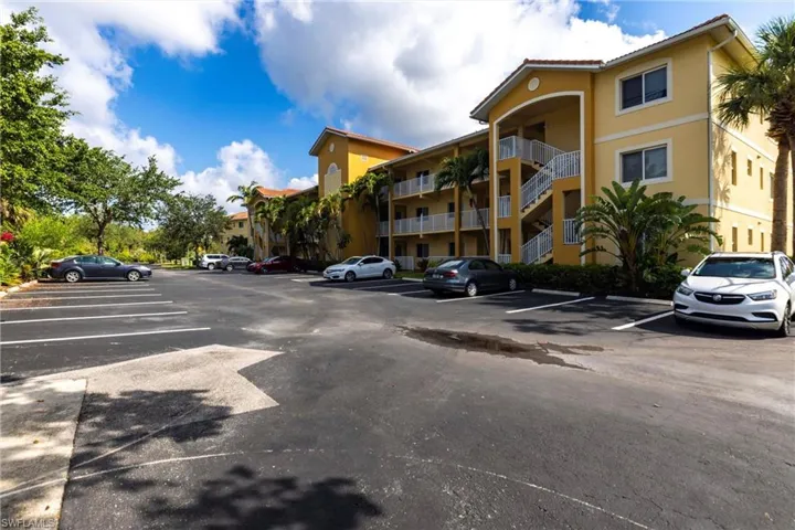 View of apartment building / complex featuring uncovered parking