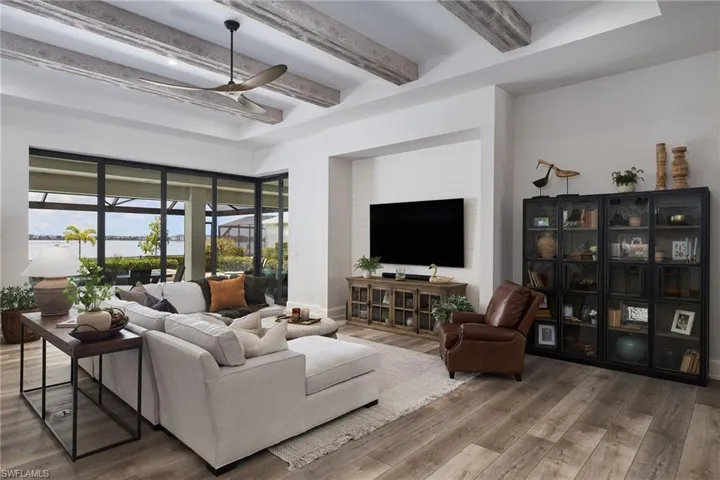 Living room with beamed ceiling, hardwood / wood-style flooring, and ceiling fan