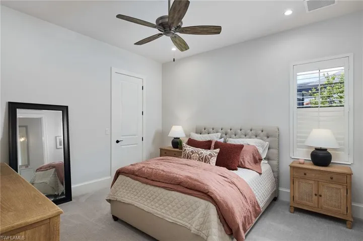Carpeted bedroom featuring ceiling fan