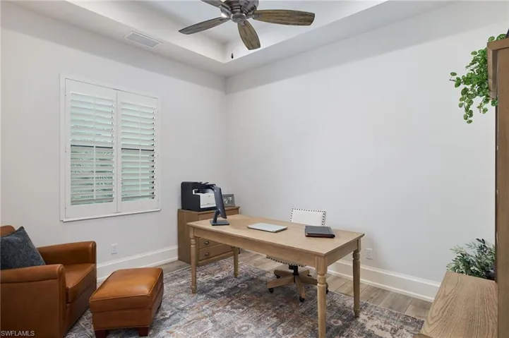 Home office featuring ceiling fan and wood-type flooring