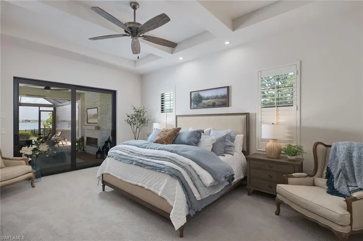 Carpeted bedroom with ceiling fan and access to exterior