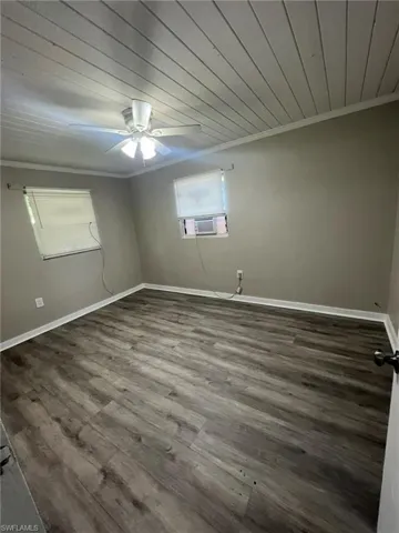 Spare room featuring crown molding, wood finished floors, a ceiling fan, wood ceiling, and cooling unit